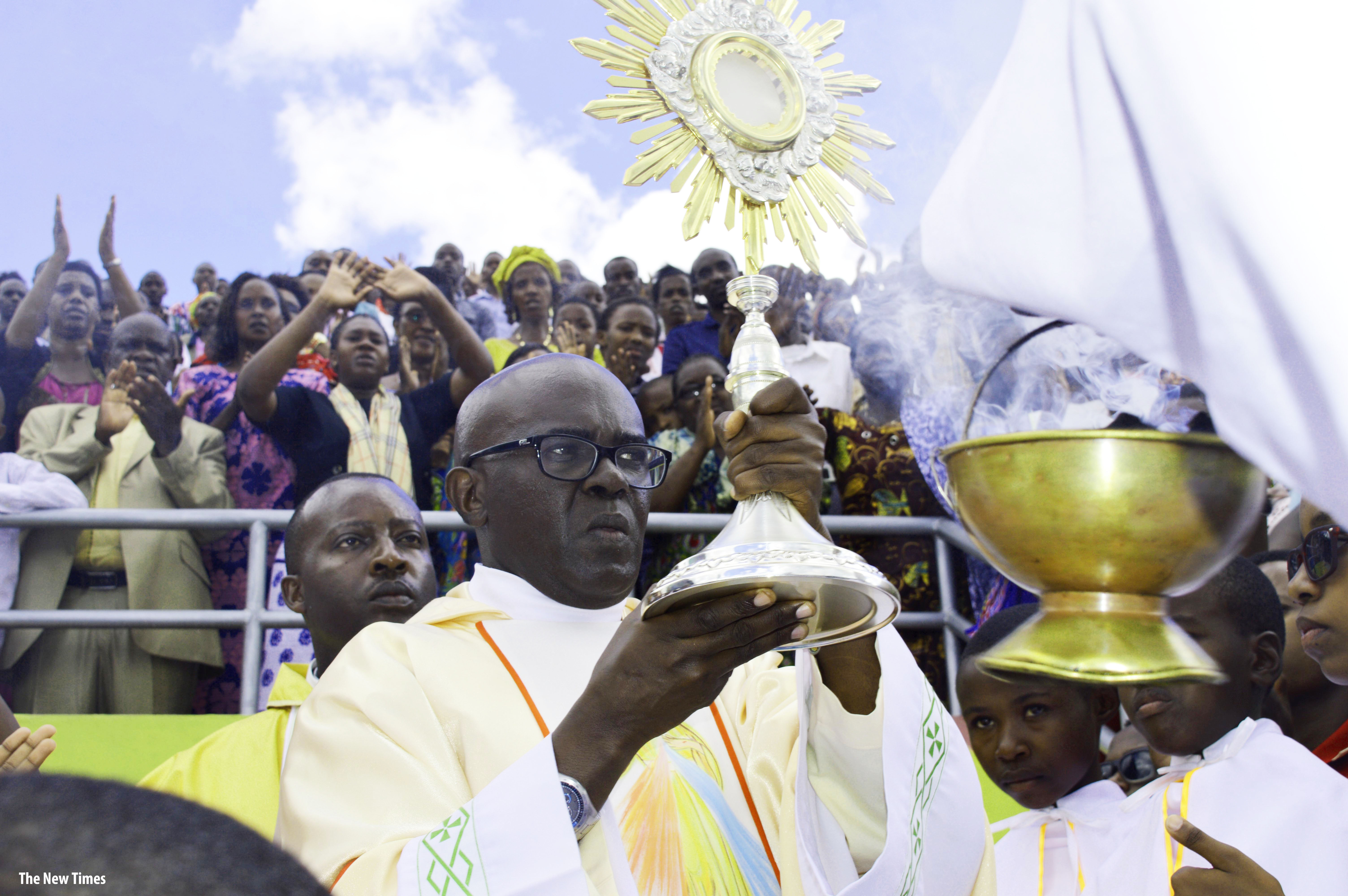 Father Ubald Rugirangoga leads holy communion at Amahoro National Stadium on April 10, 2016. 