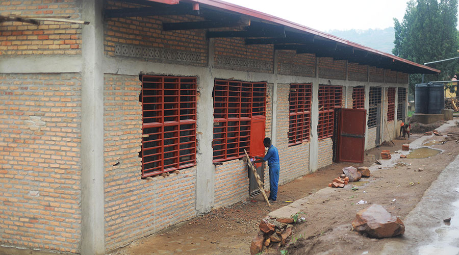 A worker paints doors and windows of newly constructed classrooms at Groupe Scolaire Kimironko I on January 13, 2020. 