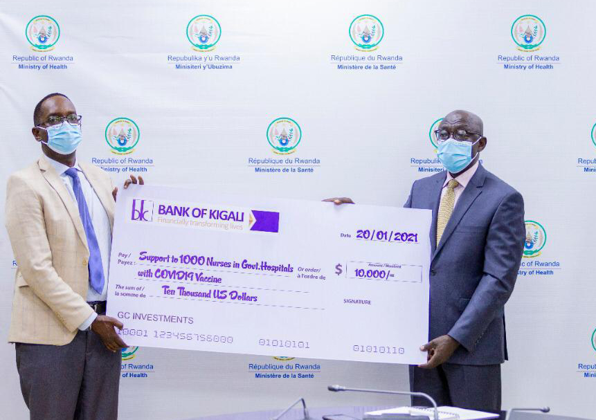Dennis Karera, the Chairperson of Gold Capital Investments (right), hands over the dummy cheque to Dr Daniel Ngamije, the Minister for Health, in Kigali over the weekend. 
