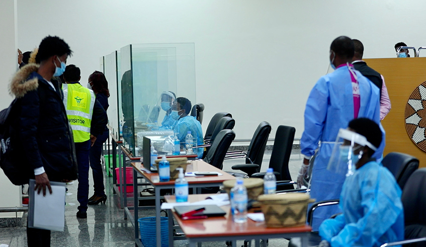 Health workers carry out Covid-19 testing on arriving passengers at Kigali International Airport last month. Incoming travellers will now be required to present a negative Covid-19 PCR test certificate obtained within 72 hours. / Photo: Olivier Mugwiza