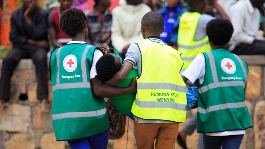 Volunteers carry a trauma victim during a commemoration event at Murambi Genocide Memorial in 2018. 
