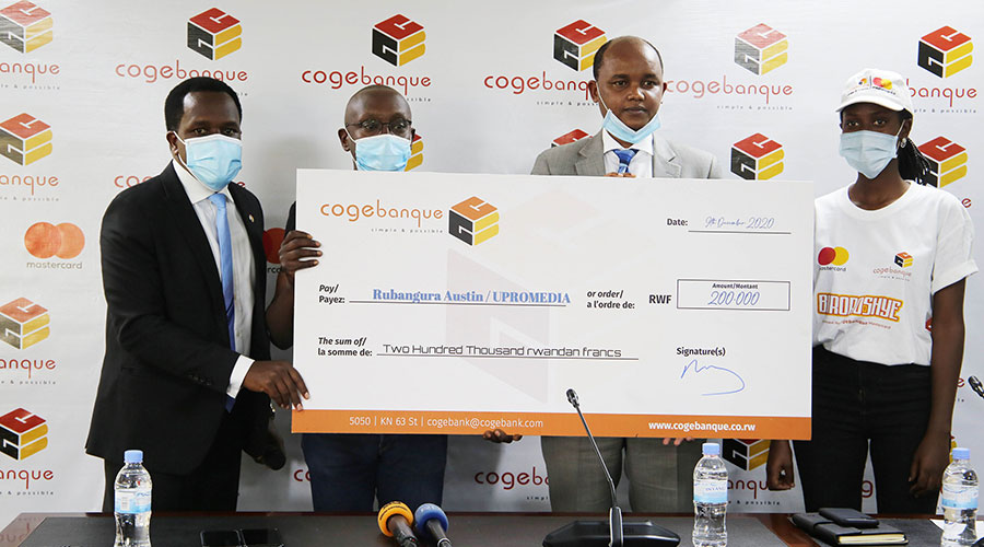Cogebanque officials hand over a cheque to one of the clients who use Mastercard. 