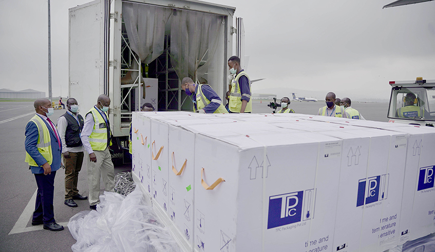 Ground cargo handlers and other officials loading the AstraZeneca/Oxford Covid-19 vaccines in a specialized truck at Kigali International Airport on Wednesday, March 3. The vaccines arrived in two batches, all totaling 342,960 doses. /  Photo: Olivier Mugwiza. 