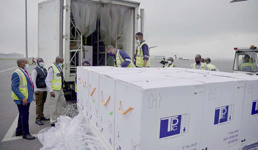 Ground cargo handlers and other officials loading the AstraZeneca/Oxford Covid-19 vaccines in a specialized truck at Kigali International Airport on March 3. / Photo: Olivier Mugwiza.