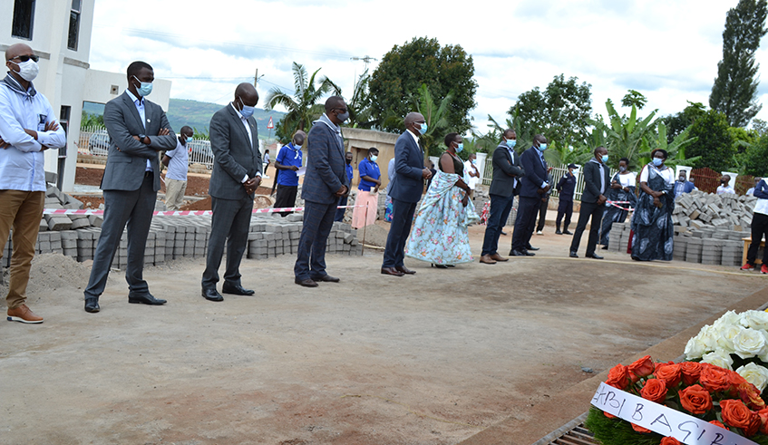 Mayor Gasana laying wreath on grave at Kiziguro genocide memorial