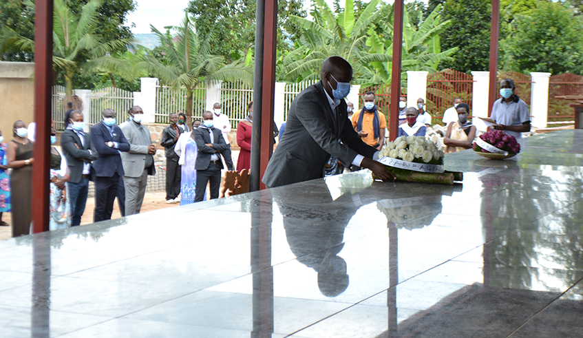 Mayor Gasana laying wreath on grave at Kiziguro genocide memorial