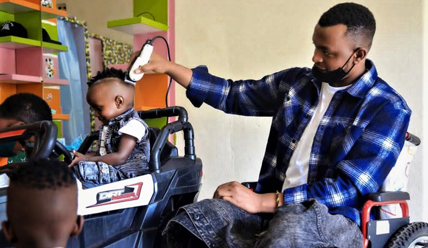 Rwampungu shaves a young boy in his saloon. The 28-year-old still dreams of continuing his career in wheelchair basketball sport. / Photos: Craish Bahizi.