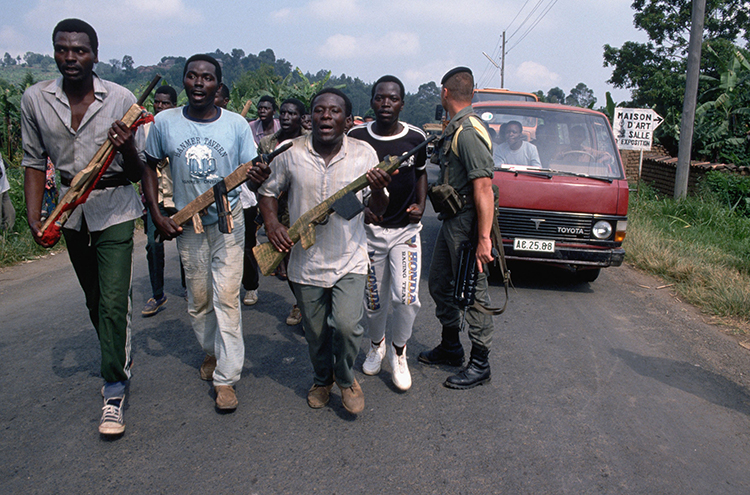 A group of Interahamwe militiamen carry model rifles during a training under the supervision of a French soldier in 1994.