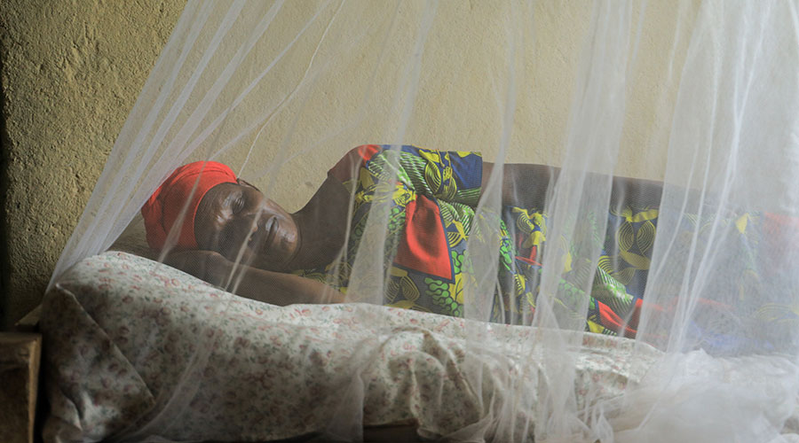 A woman sleeping under a mosquito net in Bugesera District. Mosquito nets are some of the ways that Rwanda uses to prevent malaria. 