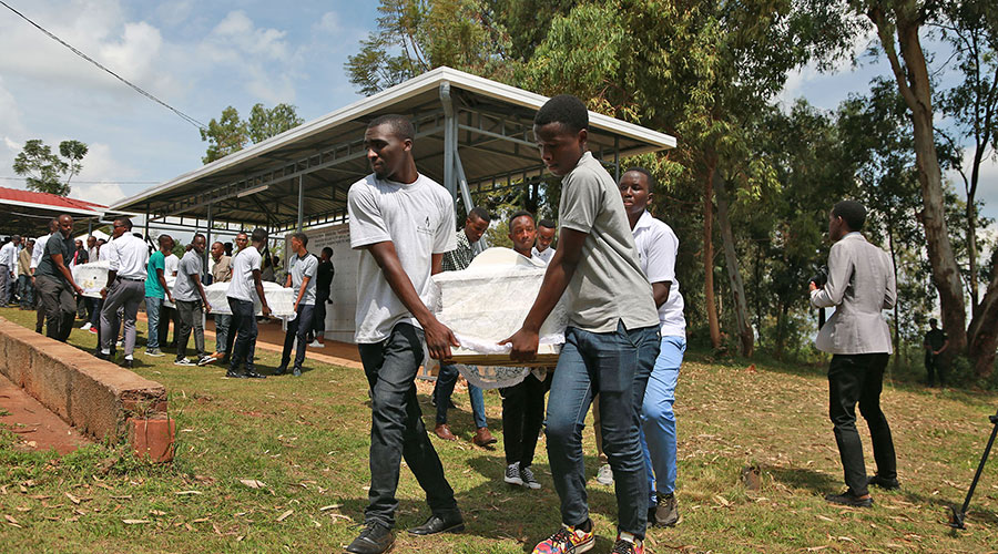 Youth carry remains of Genocide victims that were exhumed from different mass graves during an event to give them a decent burial at Nyanza-Kicukiro Genocide Memorial in 2019. 