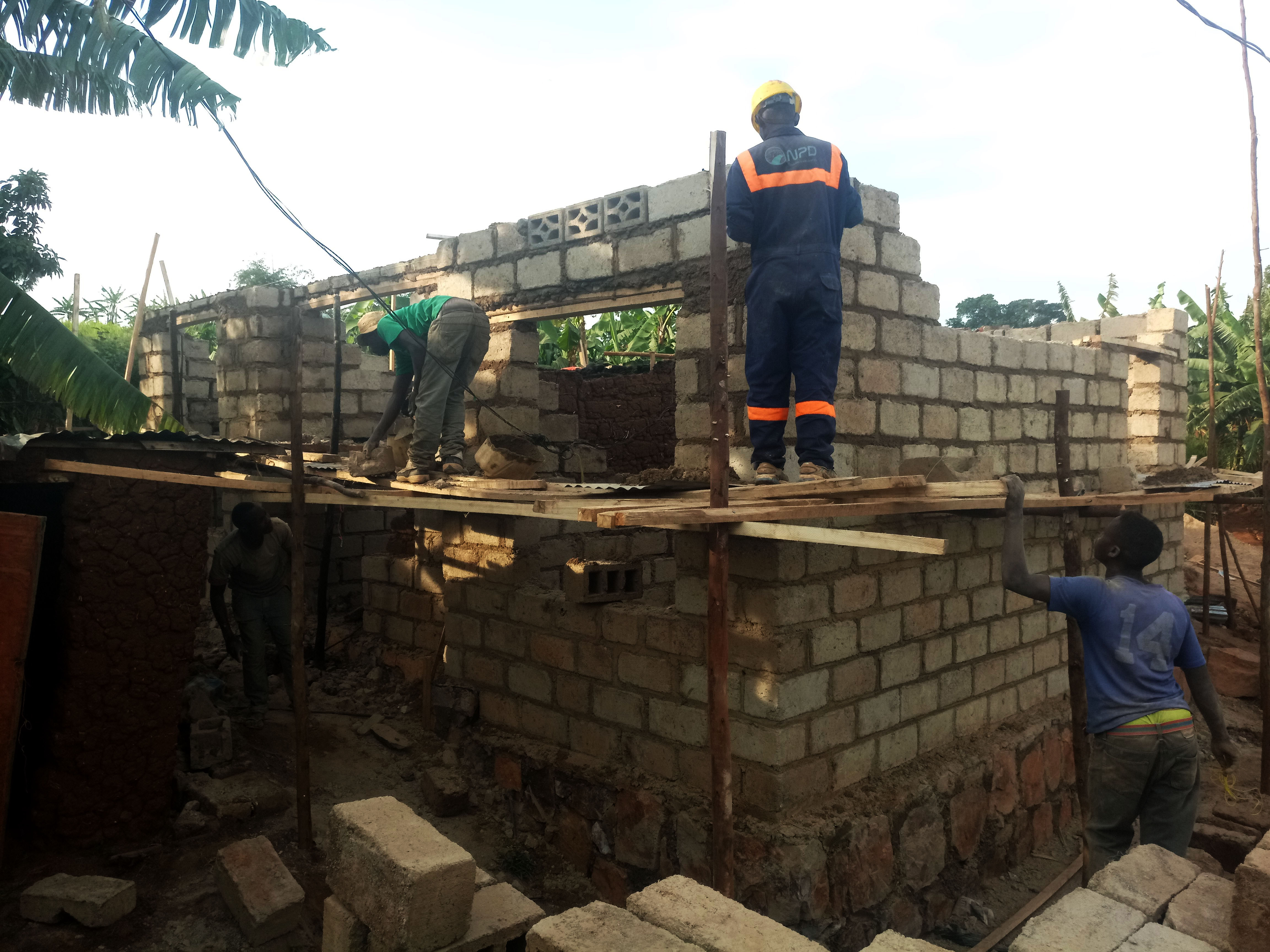 Construction workers build a house for an informal sector worker in Kigali. 