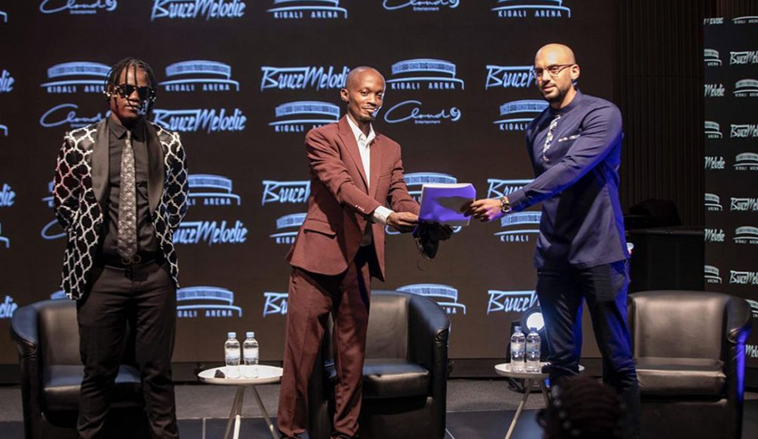 Bruce Melodie (left) and his manager recieving the agreement from QA Venue Solutionsu2019 Kyle Schofield. / Courtesy photo.