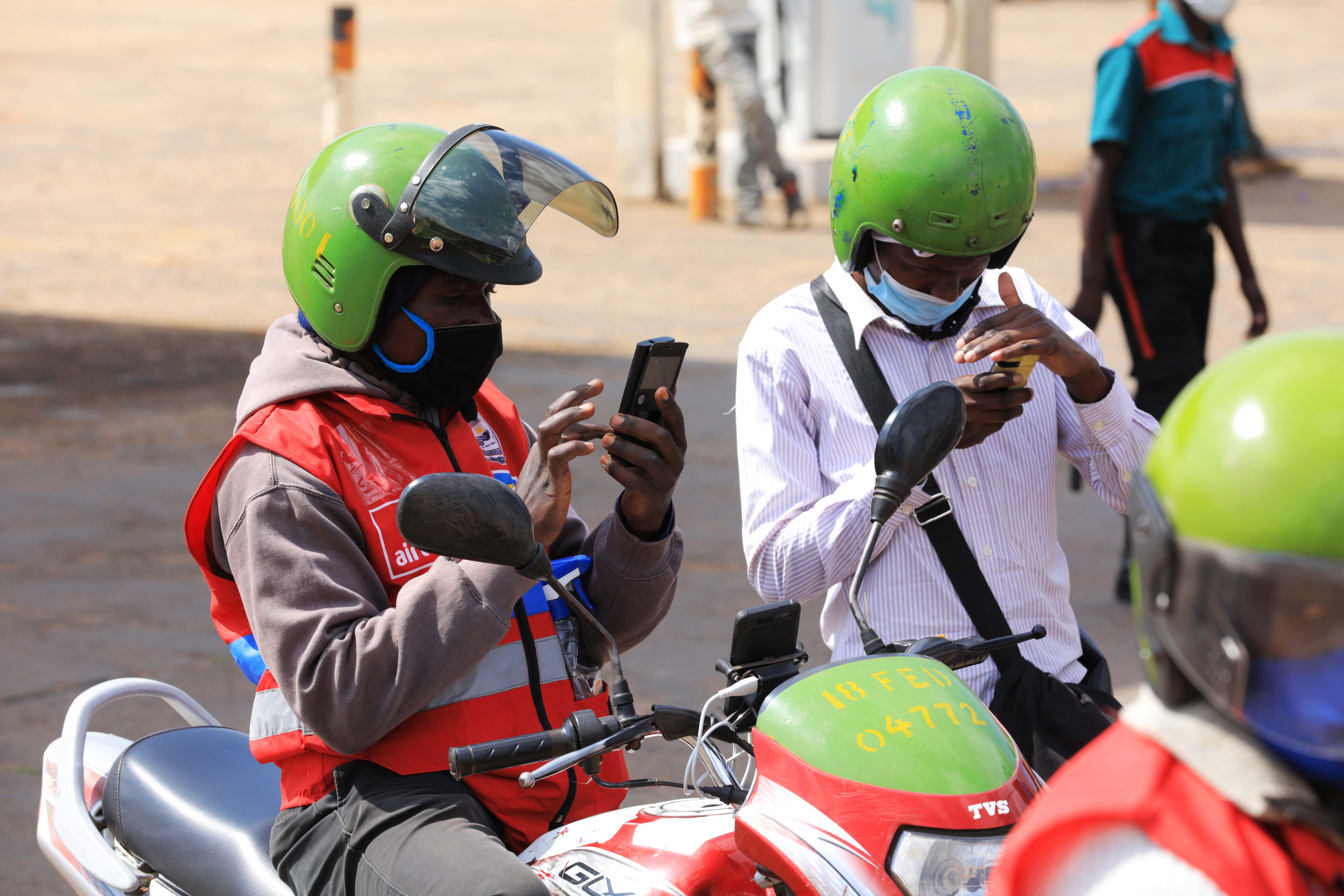 A passenger using mobile money to pay for his ride on a taxi moto in Kigali. The discrepancies in costs to pull money from oneu2019s bank account to their mobile money wallet threatens to set the country back on gains made towards cashless payments.