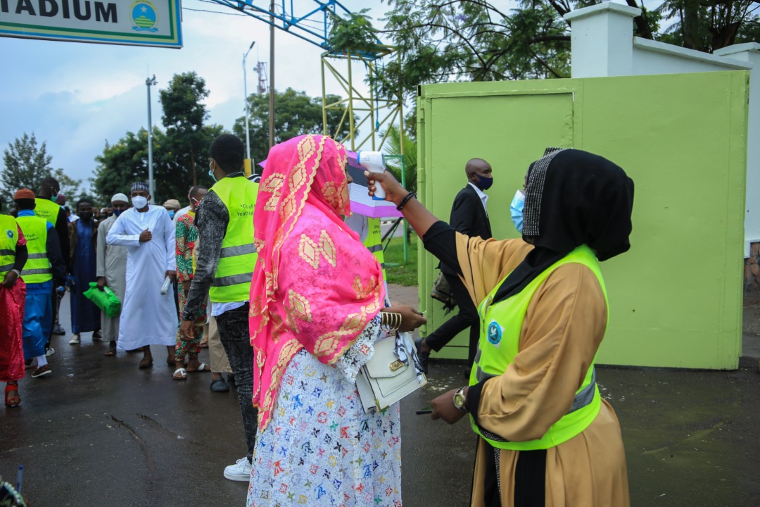 A voluteer takes temperature measures for  Muslims who attended prayers at Kigali Stadium in Nyamirambo. Celebrations were observed under Covid-19 preventive measures. (Dan Nsengiyumva)