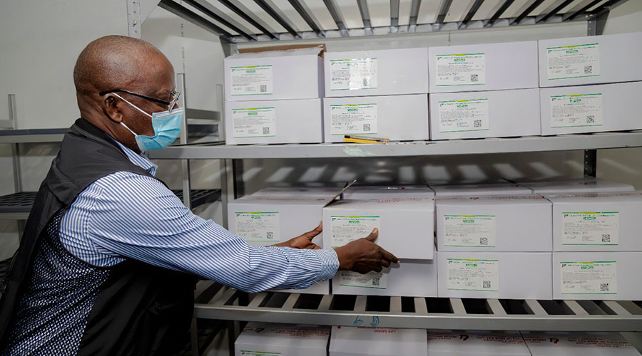 An official from Rwanda Biomedical Centre picks Covid-19 vaccine doses from a shelf in a cold room at Kigali Special Economic Zone on Thursday, March 4. / Photo: Courtesy.
