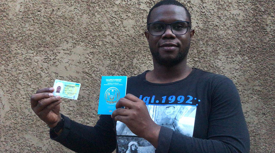 Uwizeye poses with his ID and passport.