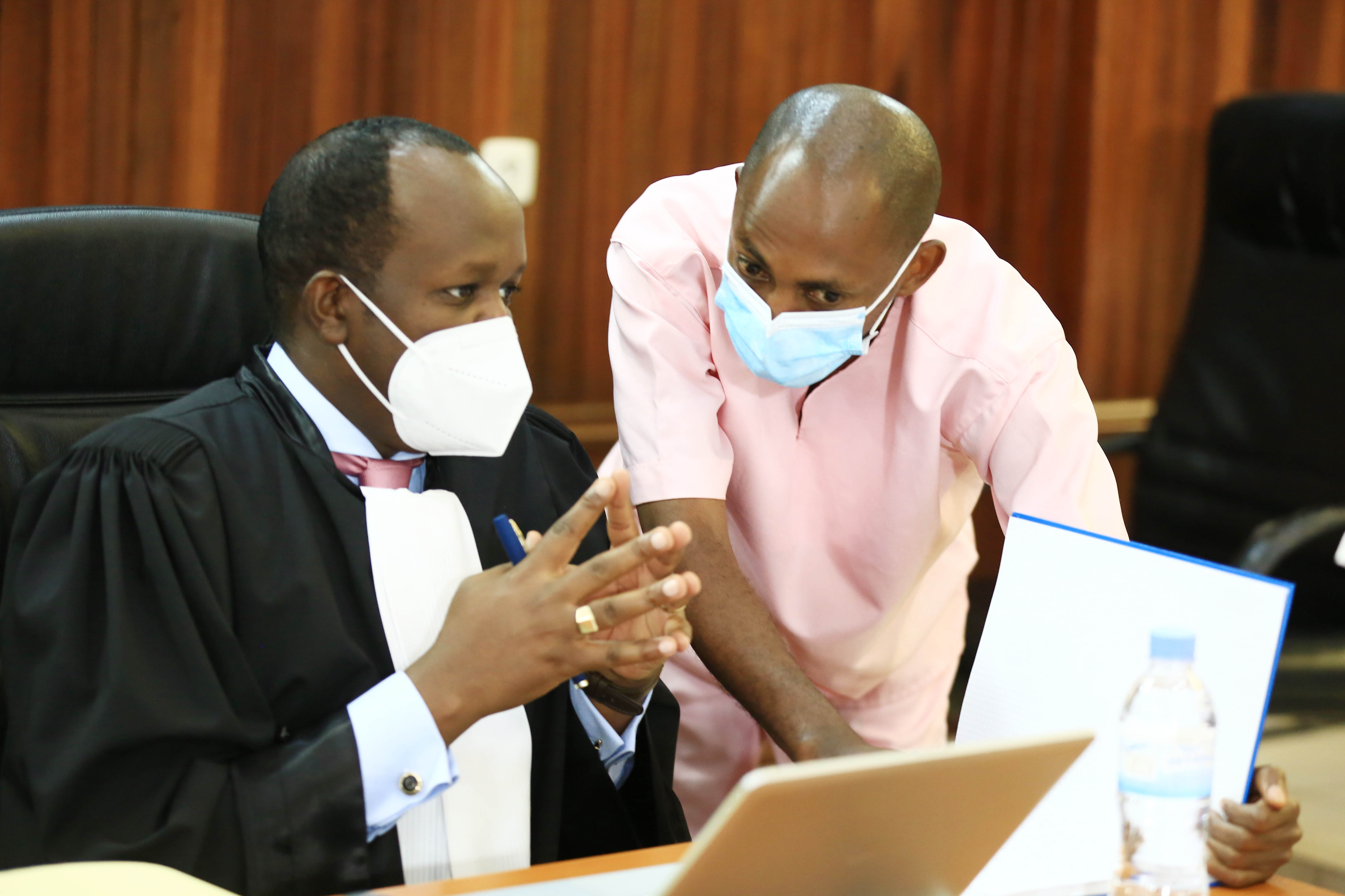Terror suspect Callixte Nsabimana, the former spokesperson and second vice president of MRCD-FLN consults with his lawyer Moise Nkundabarashi in the court . Photo by Sam Ngendahimana