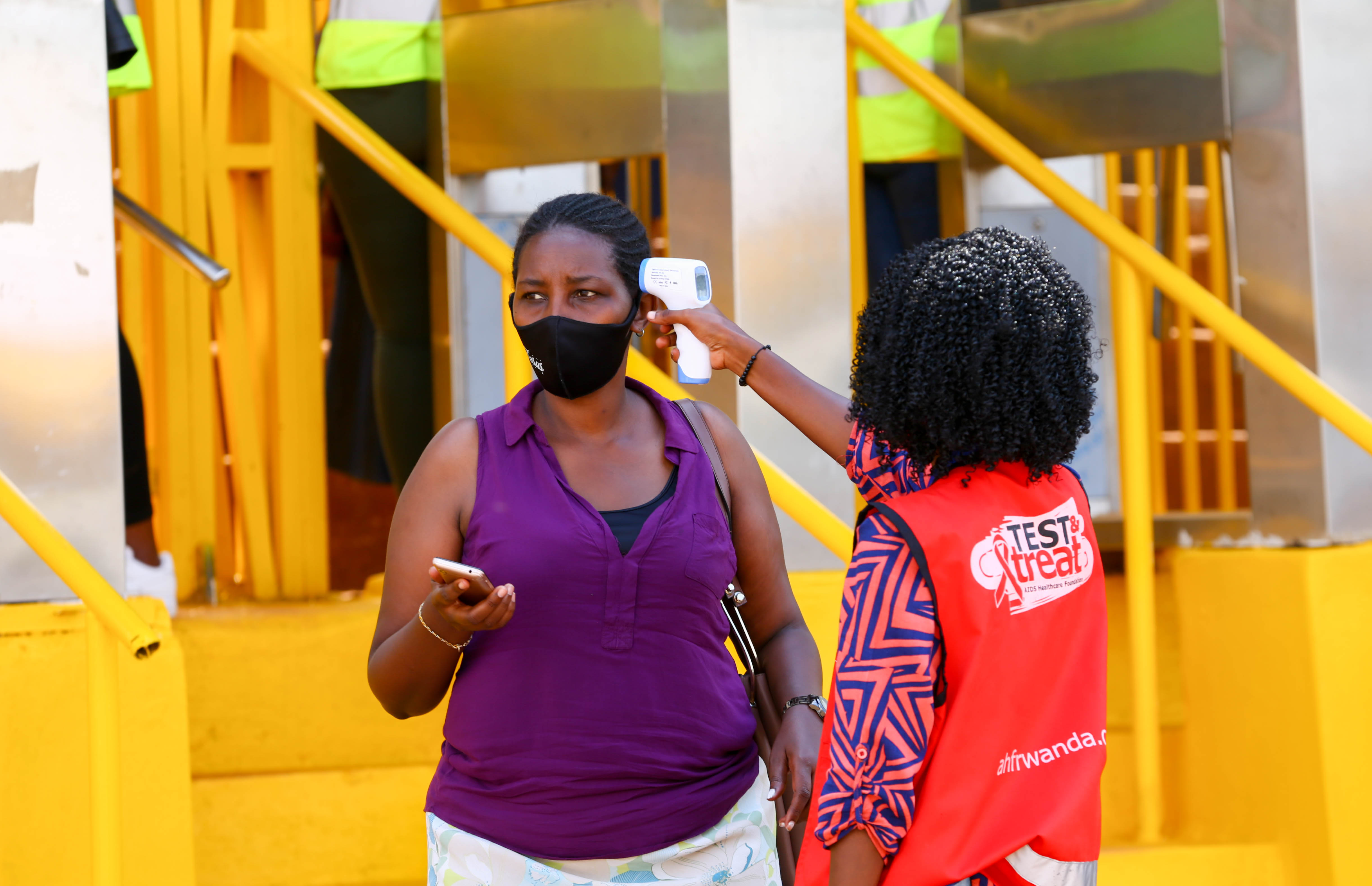 A volunteer conducts body temperature screening on an expo-goer last year in Kigali, as part of measures to help contain the spread of Covid-19. 