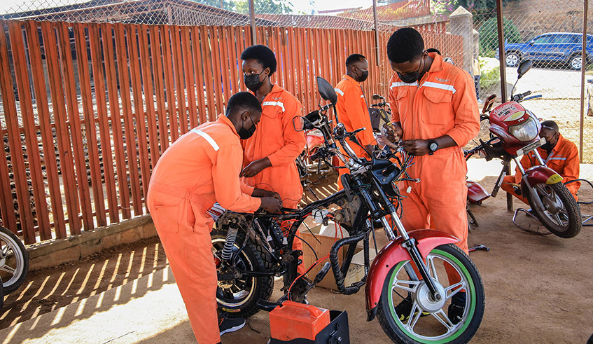 Technicians transform fuel-powered motorcycles into electric bikes in Kigali on June 10. / Photo: Dan Nsengiyumva.