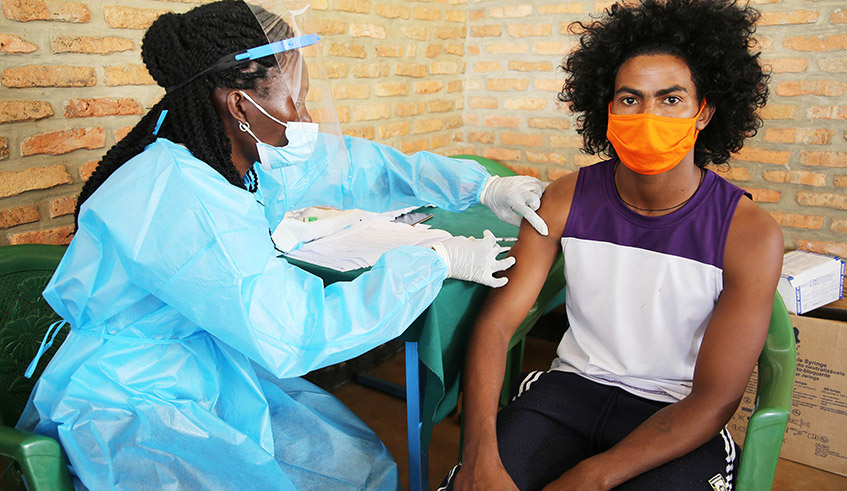 A health worker administers Covid-19 vaccine to an aylum seeker at Gashora Transit Centre in Bugesera District in March. 
