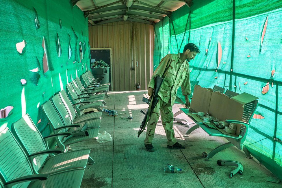 An Afghan army soldier surveys belongings left by the US military when it departed Bagram Airbase. 