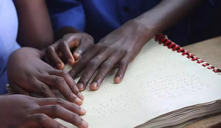 Visually impaired students read a braille textbook during a class. / Photo: File.
