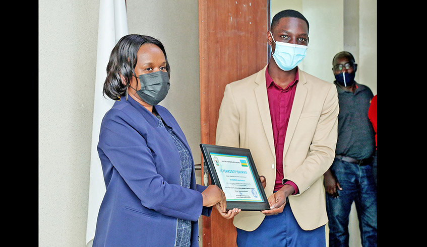 Abdulrahman Niyonizeye receives a certificate as the Best Young Entrepreneur with innovative and transformative project responding to Covid-19 challenges in Kigali on May 7. / Photo: Courtesy.