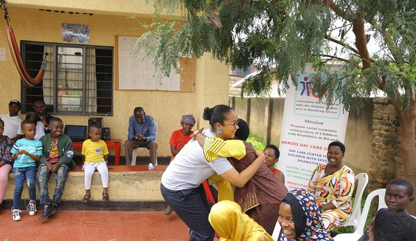 Musabyemariya hugs one of Heroes Day Care Centreu2019s sponsors from Korea as children with disabilities and their parents look on in Kicukiro District in 2018. / Photo: Courtesy.