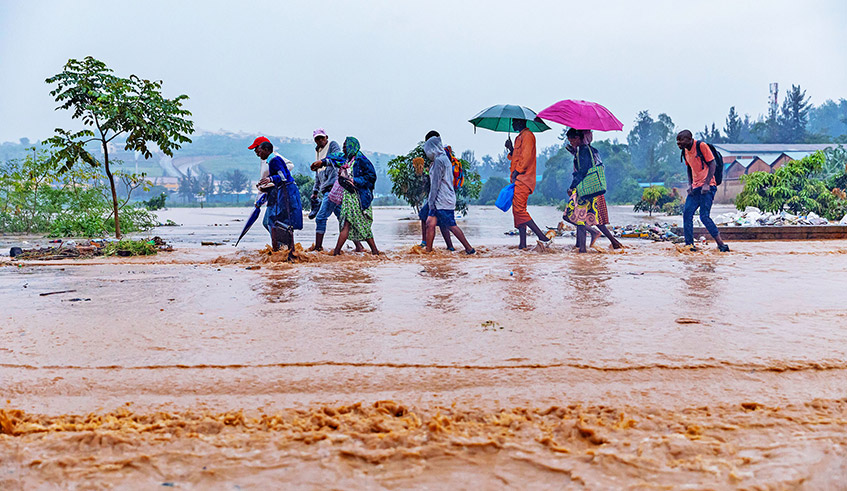 Pedestrians wade through a flooded street in Kigali in January 2020. / Photo: File.