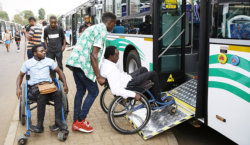 People with disabilities are assisted to board a bus at Kacyiru bus stop in 2019. / Photo: File.