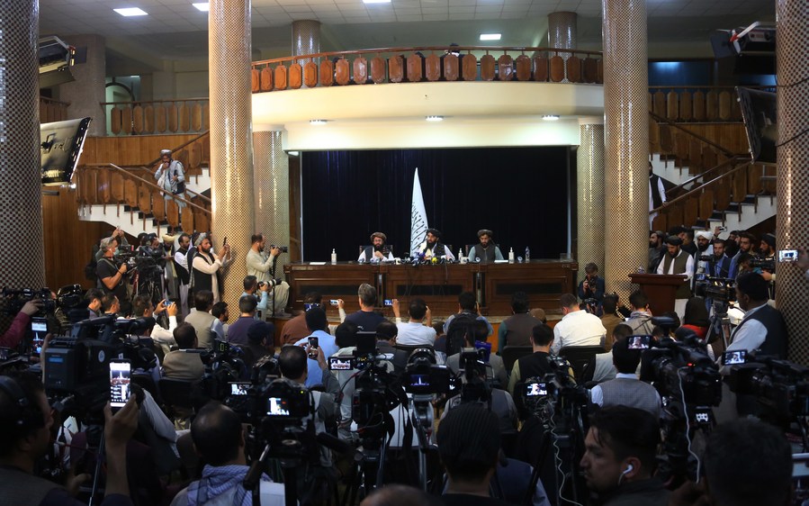 The Taliban spokesman Zabihullah Mujahid (C, rear) attends a press conference in Kabul, capital of Afghanistan, on Aug. 17, 2021. 