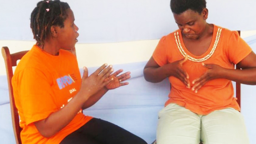 Two ladies conversing through sign language in Muhanga District. 