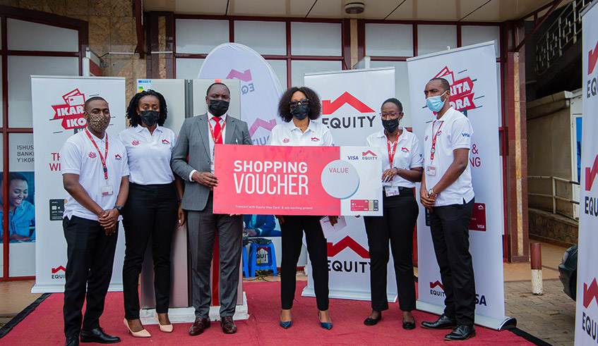 Equity Bank Rwanda officials pose with a dummy shopping voucher. To take part in this promo, clients simply need to use any Equity Visa Card to make payments. / Photos: Dan Nsengiyumva.