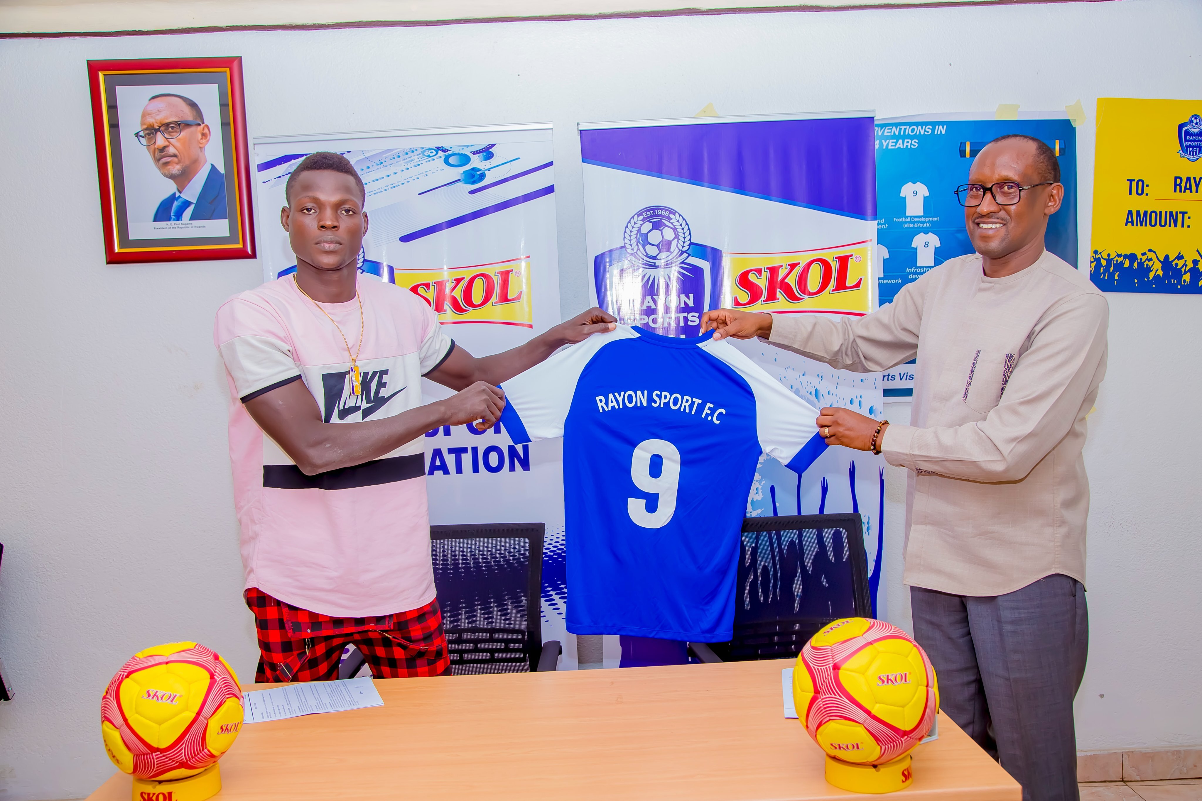 Sanogo Souleymane holds a Rayon Sports jersey after signing a two year deal. On the right is Rayon Sports president Jean-Fidu00e8le Uwazeyu. 