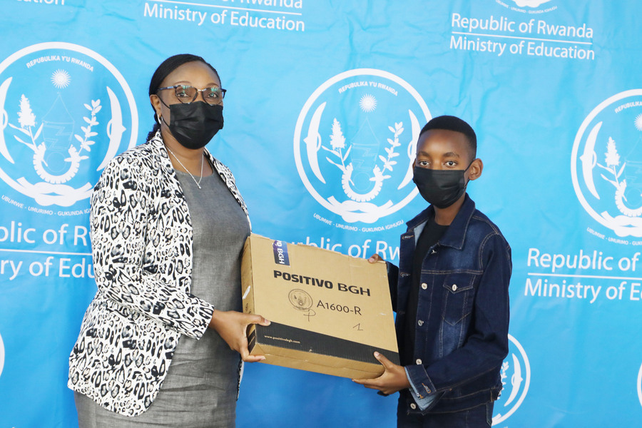 Minister of Education Valentine Uwamariya gives a laptop to  Rutaganda Yanice Ntwali, the overall winner in Primary Leaving Examination from Kigali Parents School on  October 4. 