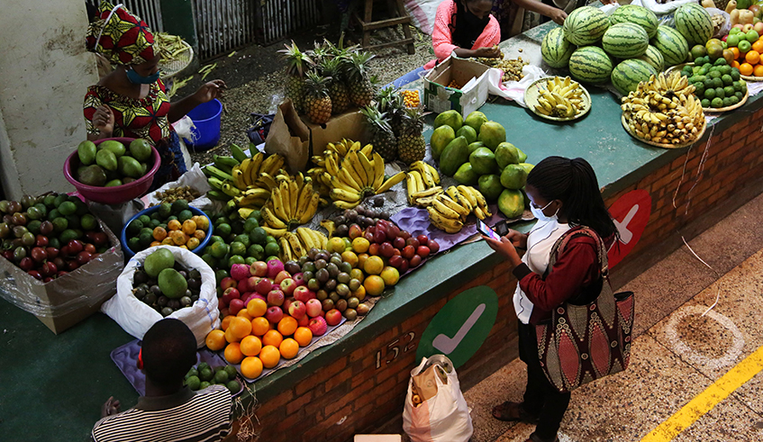 A client pays a fruit vendor by MoMo pay at Nyarugenge market. / Photo: Craish Bahizi.