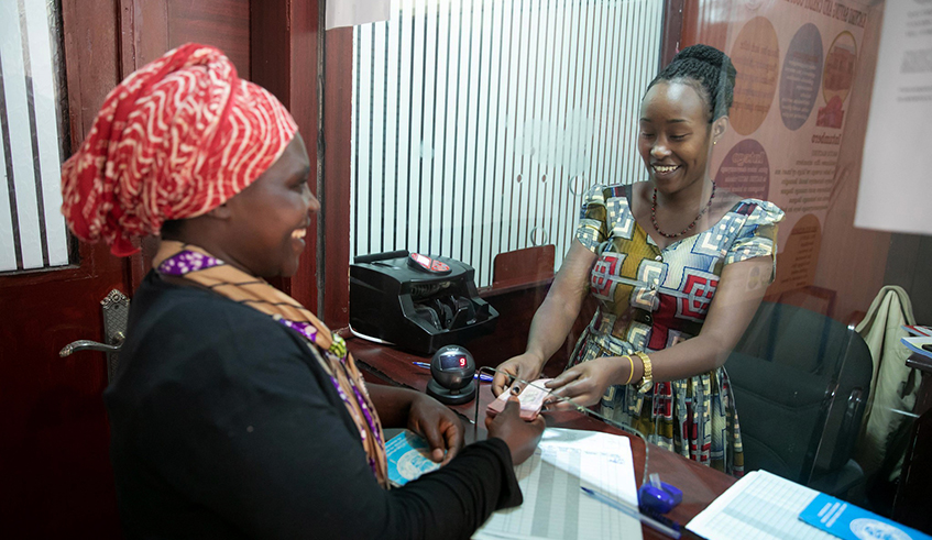 A teller serves a woman at Kacyiru SACCO in Kigali. / Photo: File.