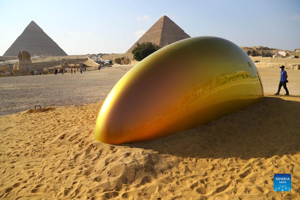 Photo taken on Oct. 21, 2021 shows an artwork in front of Giza Pyramids during an international art exhibition in Giza, Egypt. Egypt launched on Thursday the first international art exhibition at the Great Pyramids of Giza and their surrounding plateau with the participation of artists from Egypt and other countries. 