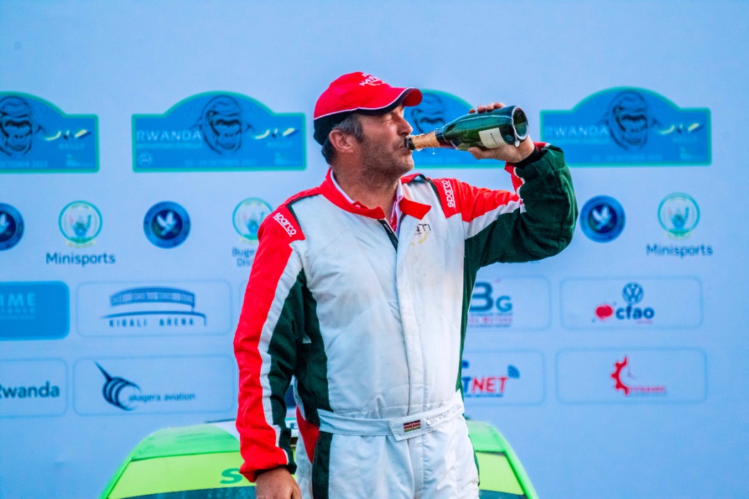 Kenyau2019s Carl Tundo celebrating by drinking Champagne after winning the 2021 Rwanda Mountain Gorilla Rally. 