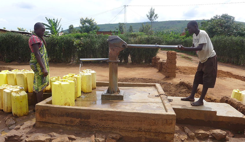 People fetch water from a borehole in rural Rwanda. Access to water is a key a part of economic development. / Courtesy