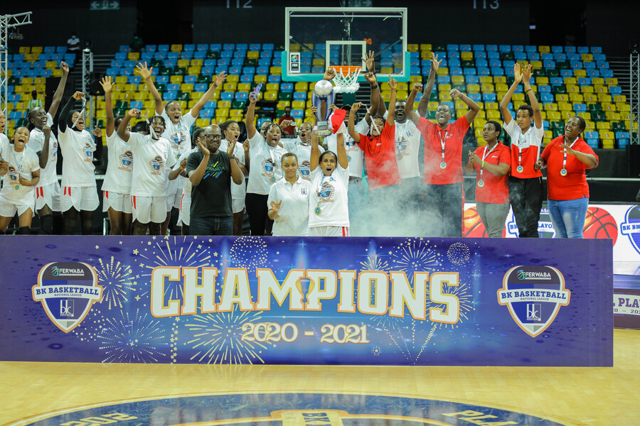 REG players, coaching staff and officials lift the trophy aloft after beating the Hoops Rwanda to win the 2020-21 championship at Kigali Arena on Sunday. 