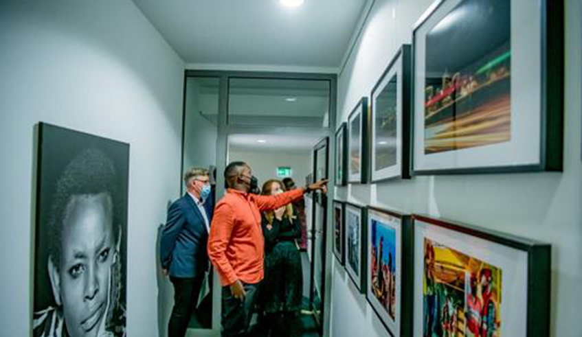 Pacifique Himbaza explaining his photos at the exhibition.