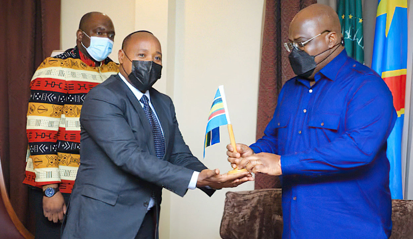 EAC Secretary General Peter Mathuki presents the East African Community  flag to President Felix Tshisekedi to mark the unveiling of the mission of DR Congo to join EAC. / Photo: Courtesy.