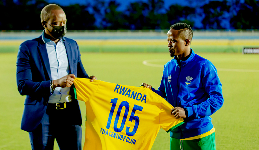 Ferwafa president Olivier Nizeyimana hands Haruna Niyonzima a jersey after he was featured in FIFAu2019s Century Club, which only includes players who have played 100 or more matches. / Courtesy.