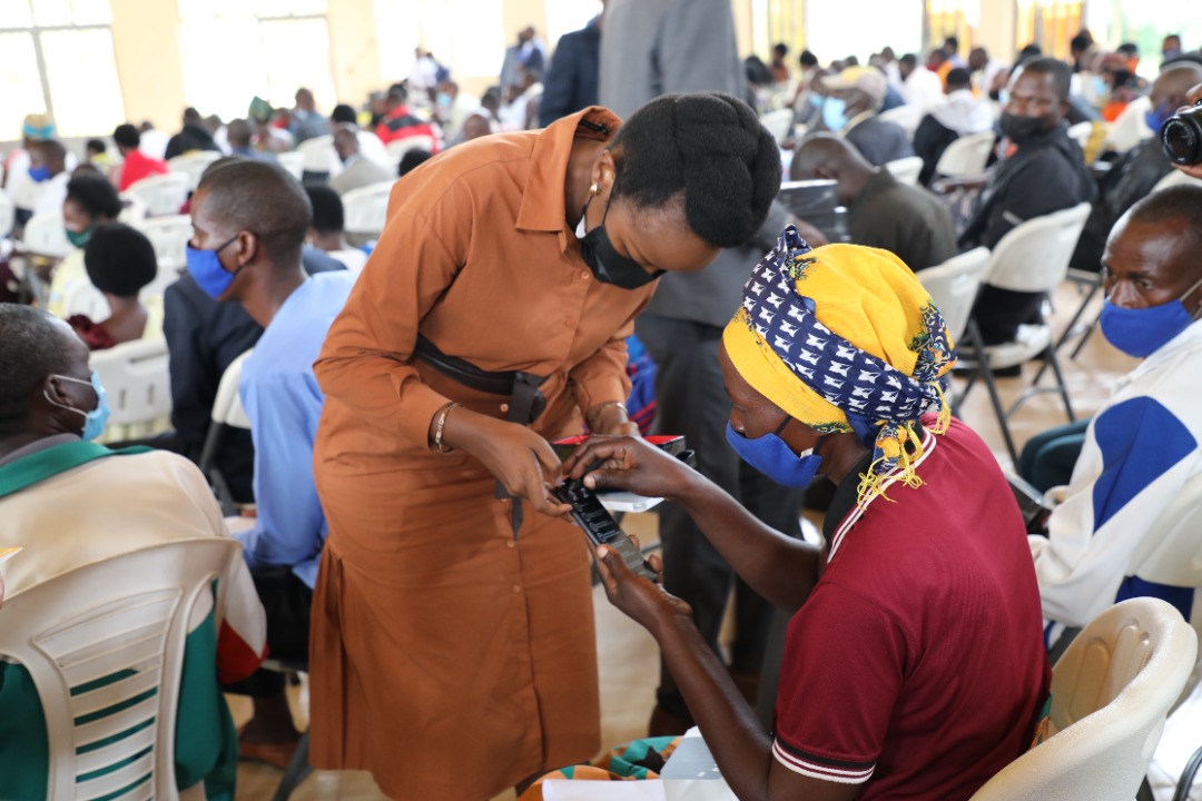 Paula Ingabire, Minister of ICT and Innovation, opening a smartphone for a resident in Bugesera District.