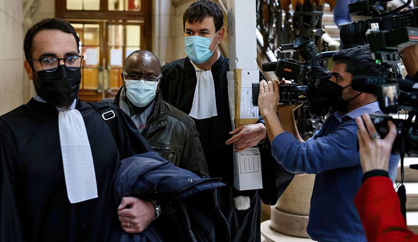 Claude Muhayimana (2nd left) follows lawyers as he arrives at the Paris courthouse on November 22