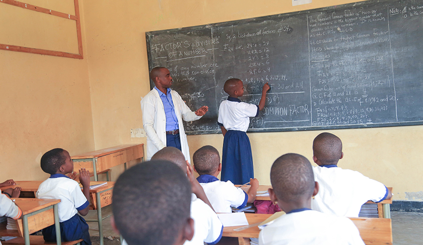 A teacher inspects a student during a class exercise in Kigali . / Craish Bahizi