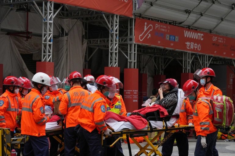 Rescue workers carry a victim on a stretcher after a fire broke out at the World Trade Centre in Hong Kong, China December 15, 2021. 