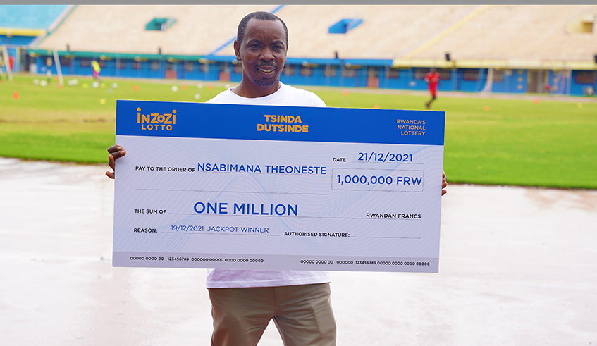 Theoneste Nsabimana who won last weeku2019s jackpot worth Rwf1 million at the ongoing lottery , poses with his cheque in Kigali on December 21. / Craish Bahizi
