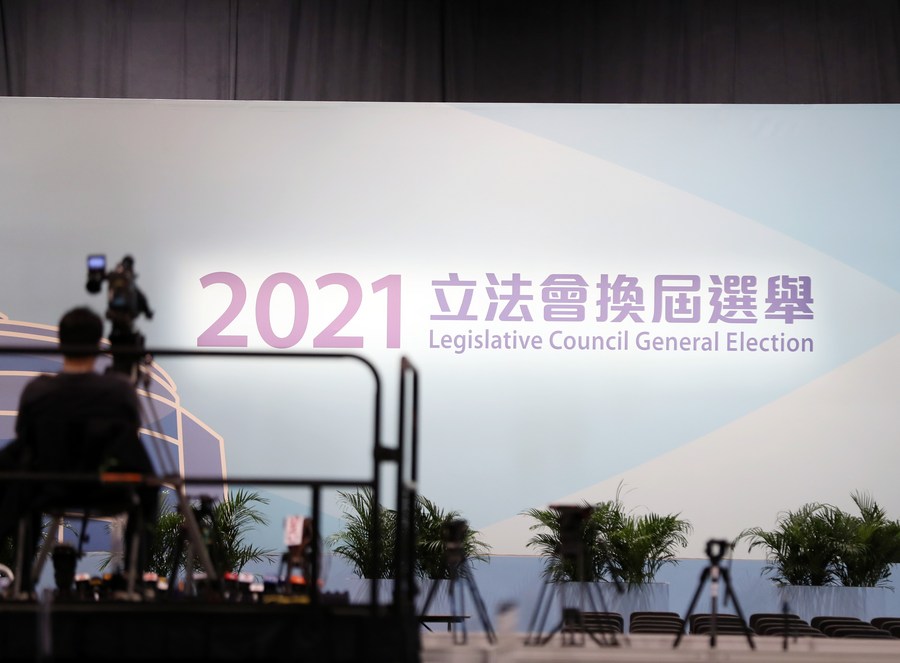A staff member debugs devices at the media center of the Hong Kong Convention and Exhibition Center in Hong Kong, south China, Dec. 19, 2021. / Xinhua/Li Gang